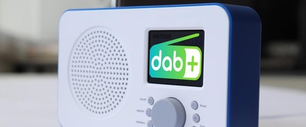 Themenbild kleines, tragbares Radiogerät in weiß mit blauem Rand und DAB+ Logo im Display