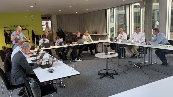 Arbeitsrunde an Tischen, die in U-Form aufgestellt sind