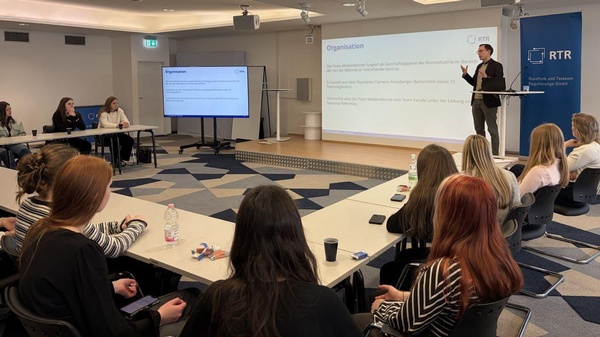 Clemens Kreutzberger-Bartenstein erläutert Schüler:innen der HLP Oberwart die Aufgaben von RTR und KommAustria