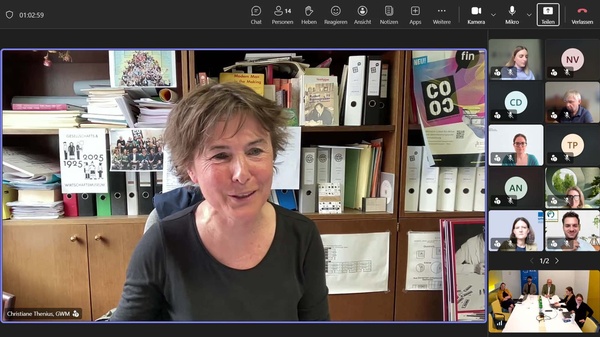 Christiane Thenius spricht per Videokonferenz aus ihrem Büro vor einem Bücherregal zu den Teilnehmenden des Medienkompetenz-Roundtables. Rechts sind weitere Teilnehmende der Online-Veranstaltung in der Kachelansicht zu sehen.