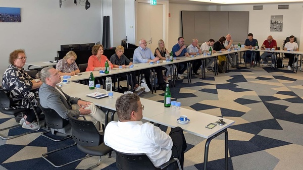 Die Besucher:innen des nordrhein-westfälischen Landtags und Mitarbeitende der RTR sitzen an einer großen, in U-Form aufgestellten Tischgruppe.