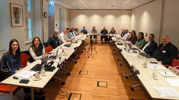 Teilnehmer der Trimediale 2026 sitzen im Besprechungsraum an Tischen, die in einer großen U-Form aufgestellt sind