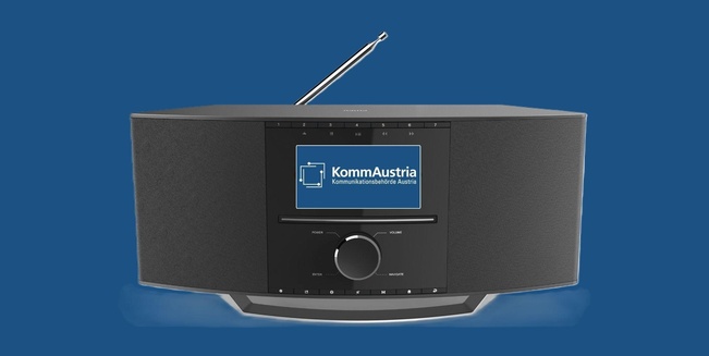 Ein Radio mit mittigem Display, auf dem das Logo der KommAustria zu sehen ist