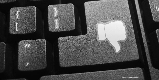 Themenbild Hass im Netz, Daumen runter auf Enter-Taste einer Computer-Tastatur.