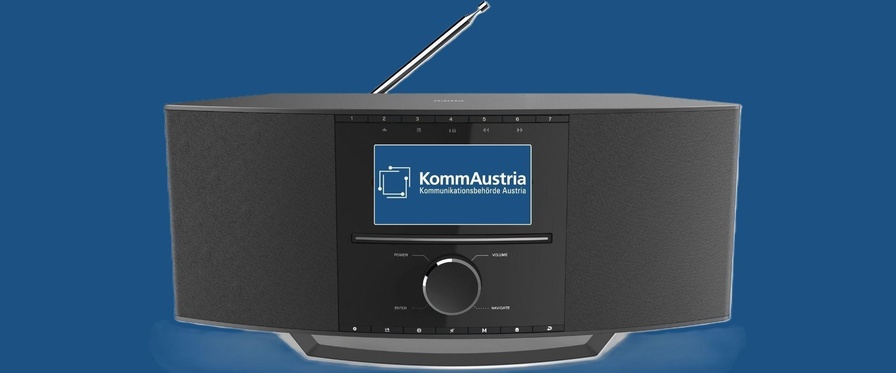 Ein Radio mit mittigem Display, auf dem das Logo der KommAustria zu sehen ist