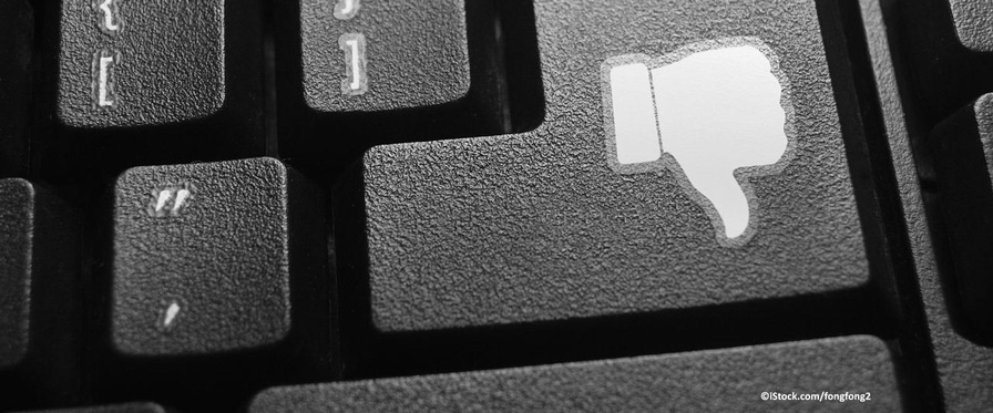 Themenbild Hass im Netz, Daumen runter auf Enter-Taste einer Computer-Tastatur.